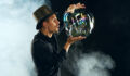Man artist blowing many soap bubble. Soap bubble show in black studio.