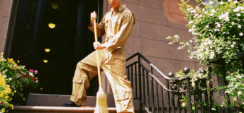 Man sweeping front porch