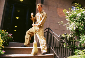 Man sweeping front porch