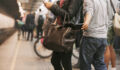 Thief stealing wallet from purse of a woman using mobile phone at the subway station. Pickpocketing at subway station
