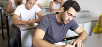 Good-looking male student writing an exam